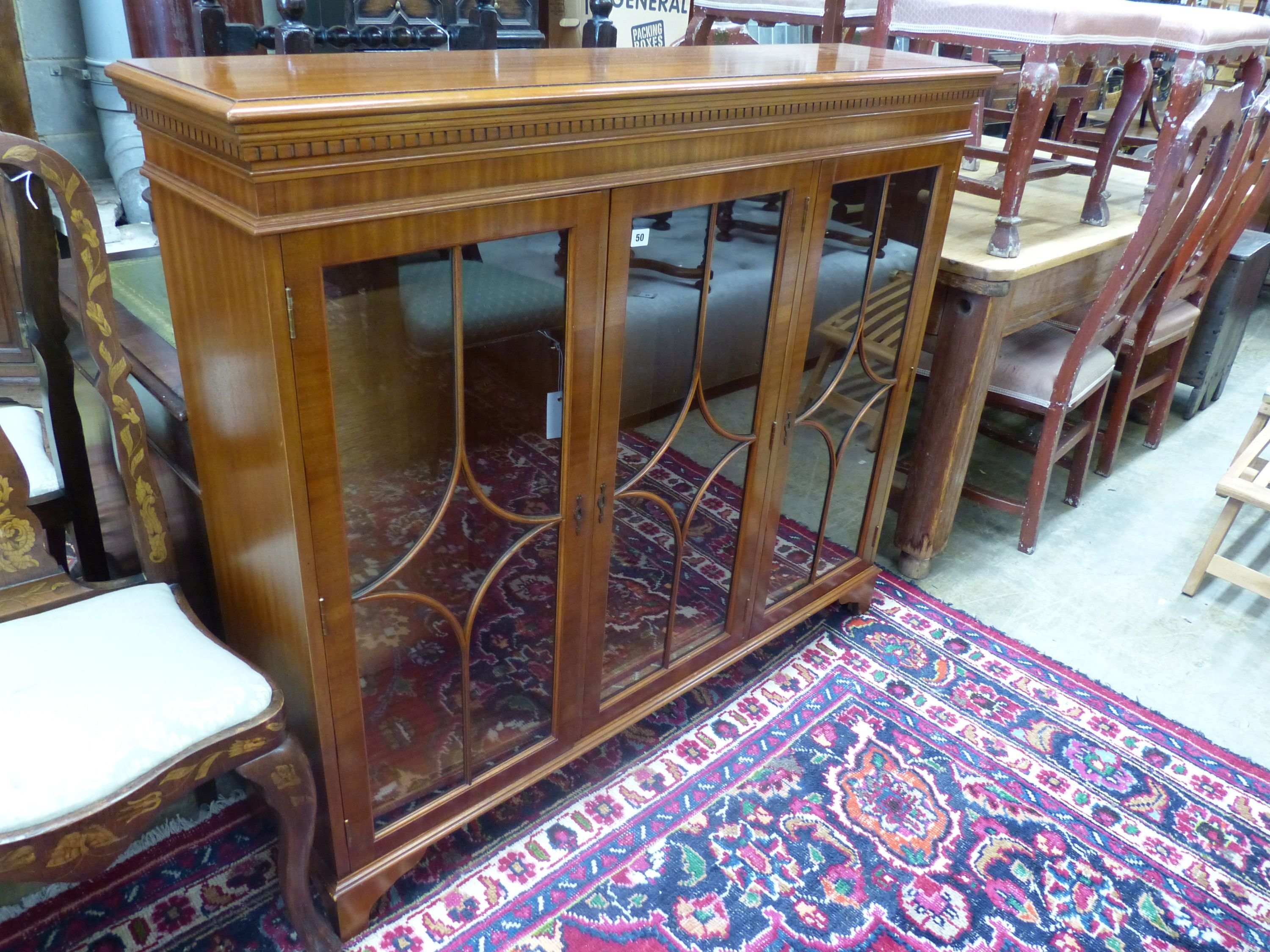 A reproduction mahogany three door bookcase, width 135cm depth 33cm height 116cm